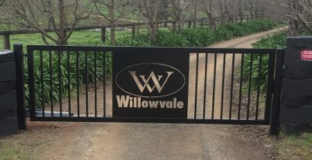 Black commercial security gate with custom Willowvale signage installed on a rural driveway in Melbourne, suited for commercial automatic gates setups