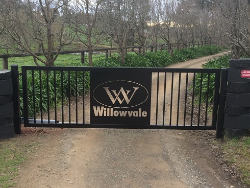Black commercial security gate with custom Willowvale signage installed on a rural driveway in Melbourne, suited for commercial automatic gates setups