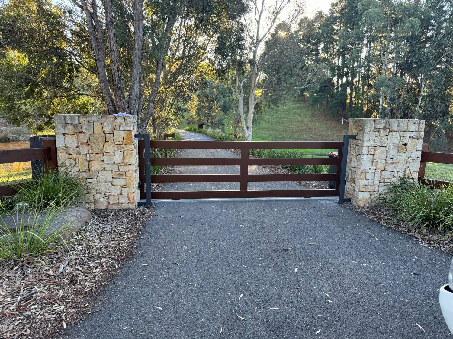 Rustic dry stone pier with horizontal rail automatic driveway gate Melbourne