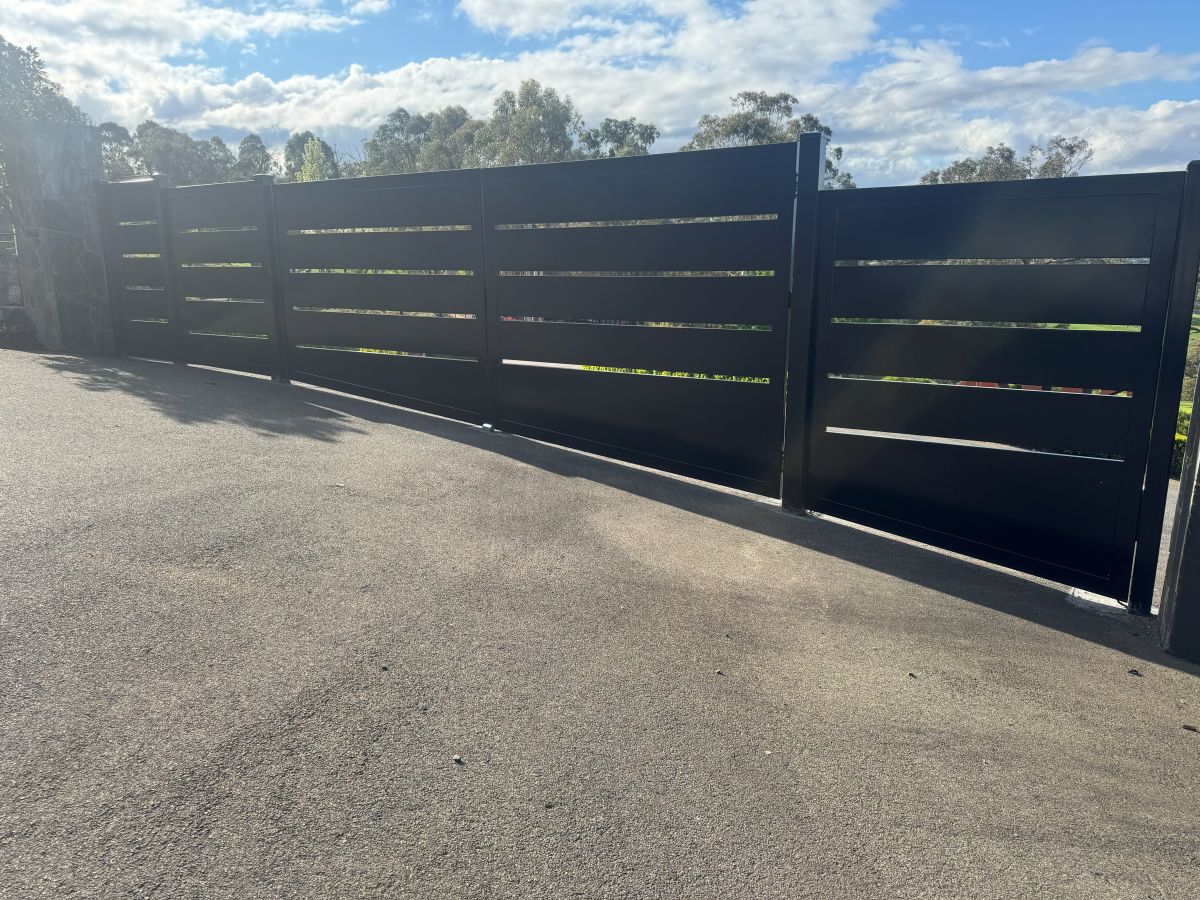 Custom black aluminium sliding gate with horizontal slat design installed on a driveway in Kangaroo Ground