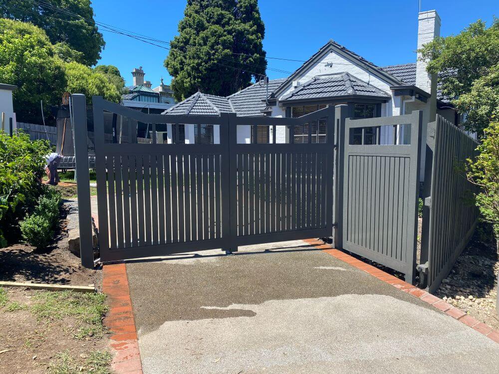 Completed installation of Hampton-style aluminium double swing gates and matching boundary fence panel.